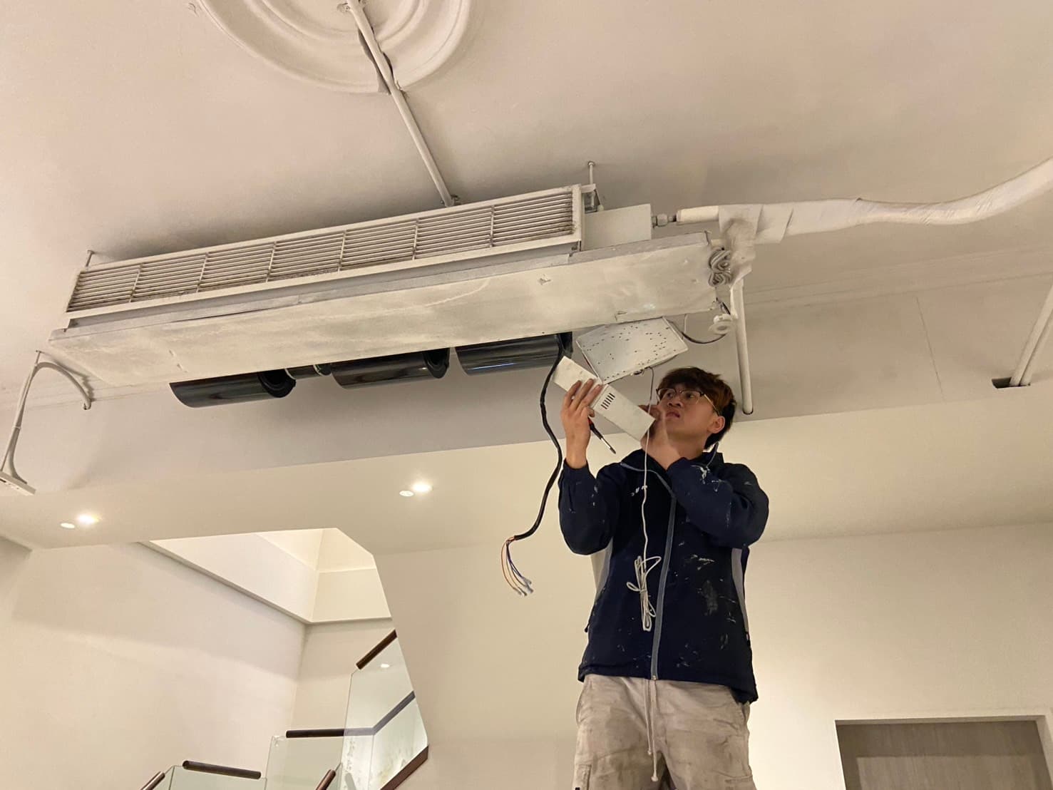 師傅在天花板夾層內進行吊隱式冷氣完工檢測